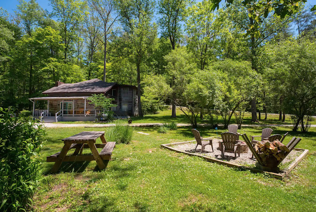 Creekside Log Cabin Airbnb exterior with firepit 