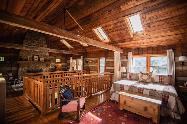 Covered Bridge Log Cabin upstairs bedroom with fireplace